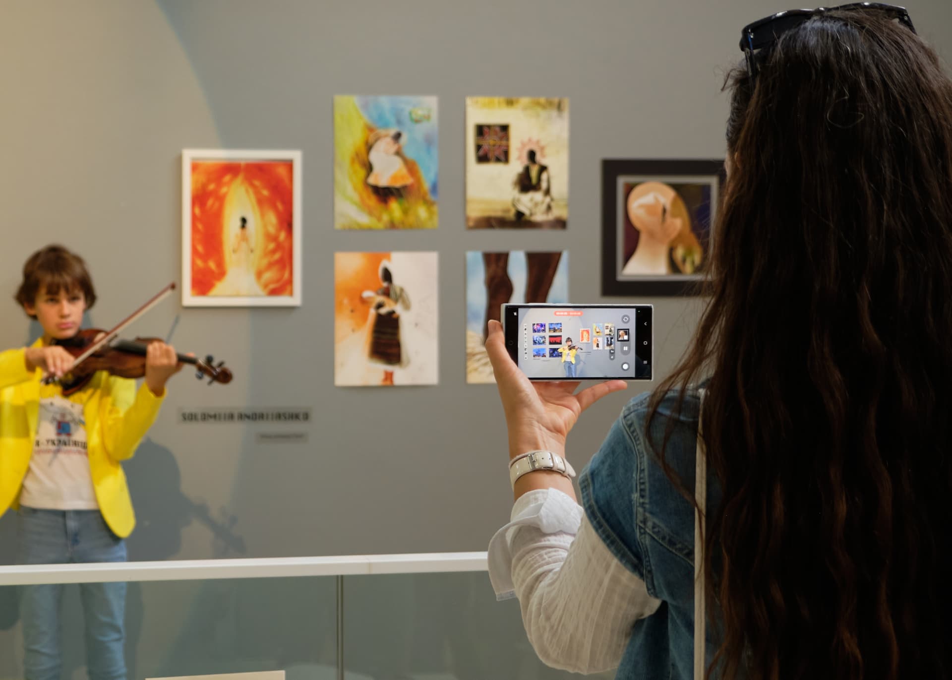Visitors photographing the exhibited works
